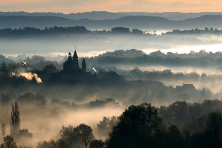 Collonges-la-Rouge backlit on a misty morning, Correze, France