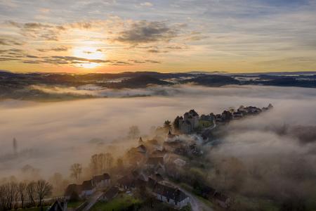 Aerial view of Curemonte surrounded by mist at sunrise, Correze, France