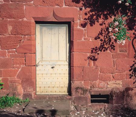 Door and roses in Collonges-la-Rouge, Correze, France