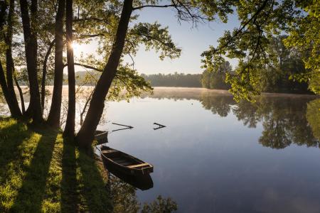 A wooden rowing boat moored on the Dordogne river, Lot, France