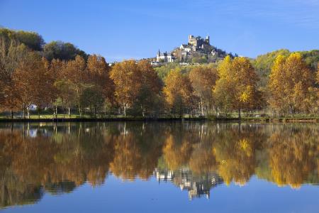 Turenne reflected in a lake in the autumn; Correze, France