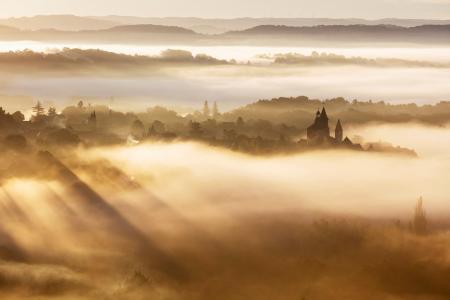 Collonges-la-Rouge village backlit on a misty morning, Correze, France